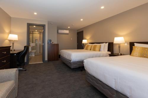 a hotel room with two beds and a couch at Motel au Vieux Piloteux in Rivière-du-Loup