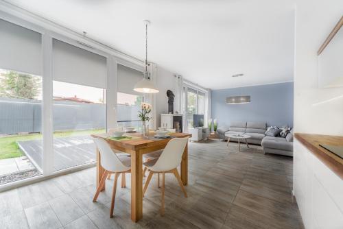 a dining room and living room with a table and chairs at Morska Bryza in Łukęcin