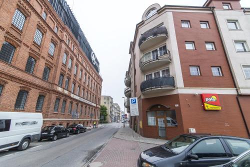 a city street with cars parked next to a building at LuxApart Kalisz Loft in Kalisz