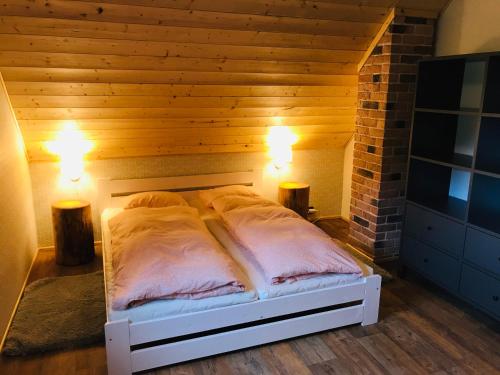a bed in a room with two lights on at Roubenky Bublava in Bublava