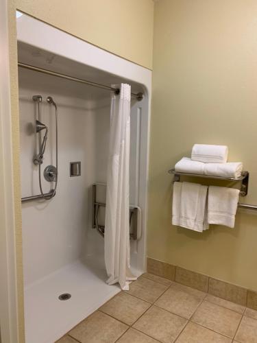 W łazience znajduje się prysznic z zasłoną prysznicową i ręcznikami. w obiekcie Holiday Inn Express Hotel & Suites Pampa, an IHG Hotel w mieście Pampa