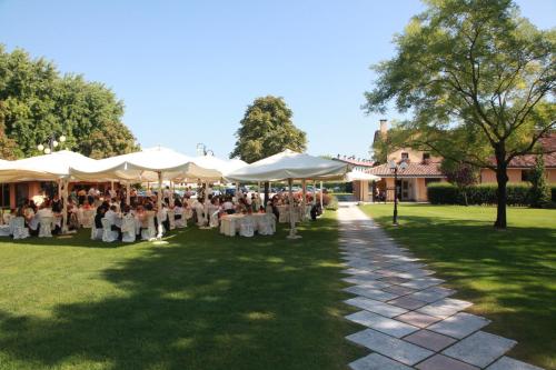 a group of people sitting under white umbrellas at Villa Dei Dogi in Caorle