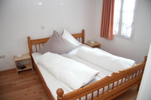 ein Bett mit weißer Bettwäsche und Kissen darauf in der Unterkunft Ferienwohnung Dürbaum in Schleiden