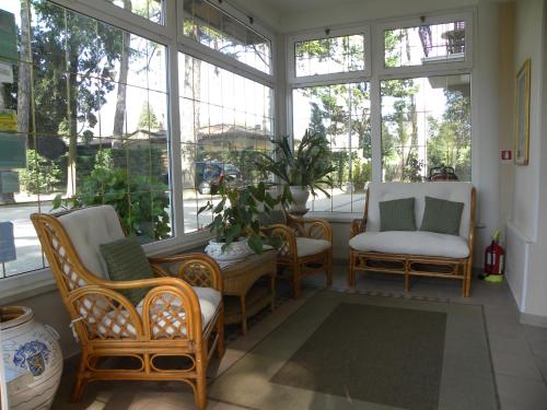 a screened in porch with chairs and windows at Hotel Kursaal in Passignano sul Trasimeno