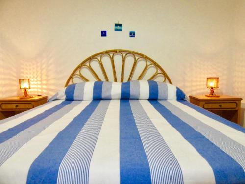 um quarto com uma cama azul e branca com 2 candeeiros em Villa Maria em Torre Lapillo