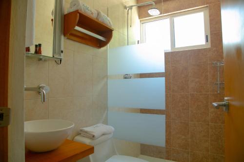 uma casa de banho com um lavatório, um WC e uma janela. em Relax Inn Suites em San Andrés Tuxtla