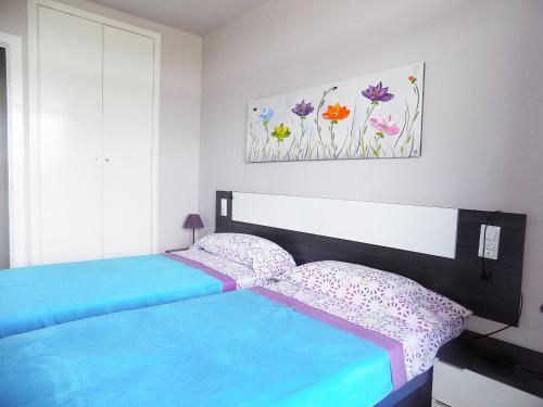 a bed in a bedroom with a white bedspread at Apartsalou Lea in Salou