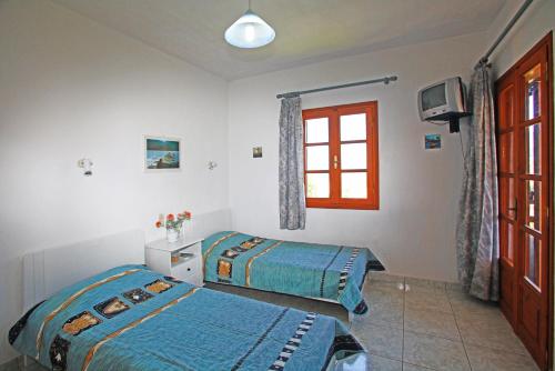a bedroom with two beds and a window at Villa Maro in Skopelos Town