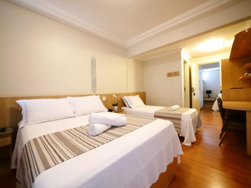 una habitación de hotel con 2 camas y un piano en Icaraí Praia Hotel, en Niterói