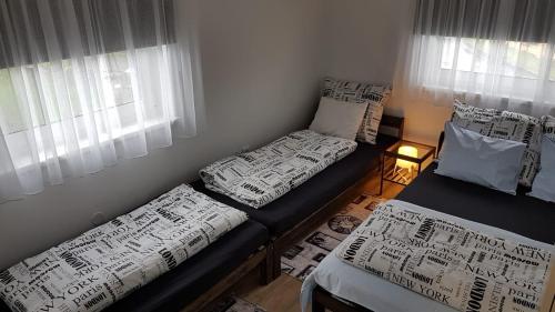a room with two beds and a window at Apartmány Tylovice in Rožnov pod Radhoštěm
