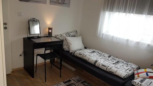 a room with a desk and a bed with a mirror at Apartmány Tylovice in Rožnov pod Radhoštěm