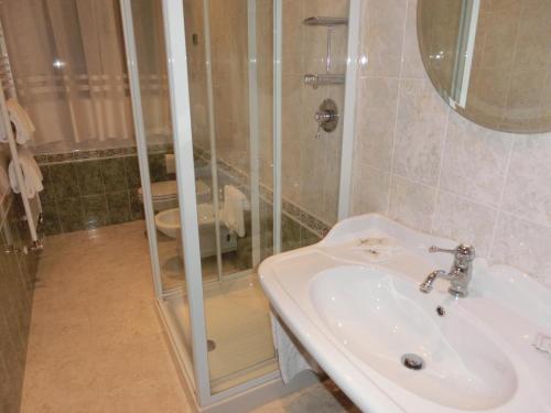 a bathroom with a white sink and a shower at Villa Dei Dogi in Caorle