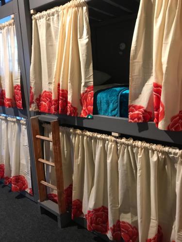 a row of red and white blankets on a bed at The Birds Nest Hostel in London