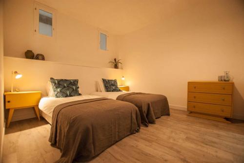 a bedroom with two beds and a dresser and two lamps at La Calade in Montouliers