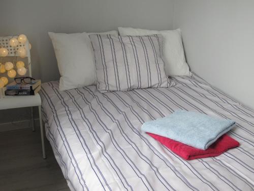 a bed with two pillows and a red blanket on it at Apartament Mierzeja in Sztutowo