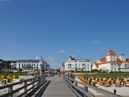 a bridge over a beach with people sitting on chairs at Direkt am Strand mit Meerblick und Sauna - FeWo Strandidyll in Binz
