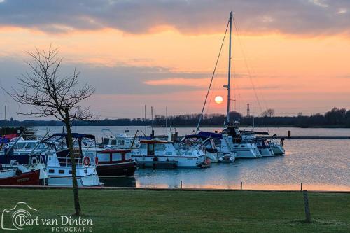 a group of boats docked in the water at sunset at Loft 8 Linden in Groot-Linden