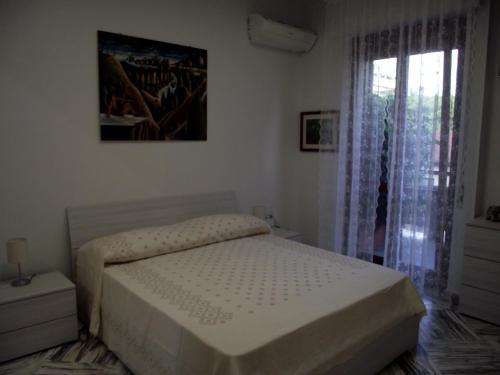 - une chambre blanche avec un lit et une fenêtre dans l'établissement Casa dei limoni, à Catane