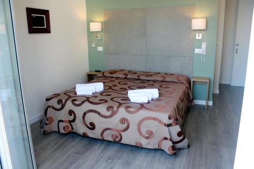 a bedroom with a bed with a brown blanket at Hotel Helga in Caorle