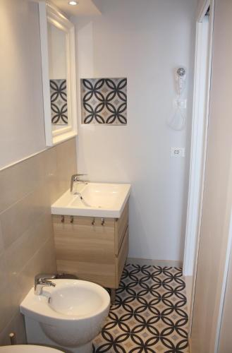 a white bathroom with a sink and a toilet at Hotel Helga in Caorle