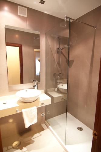 a bathroom with a sink and a glass shower at Pisos Centro Ribadesella in Ribadesella