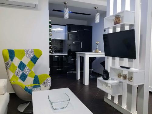 a living room with a tv and a chair and a table at Sky Apartments Special in Strumica
