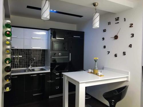 a kitchen with a white table and a clock on the wall at Sky Apartments Special in Strumica