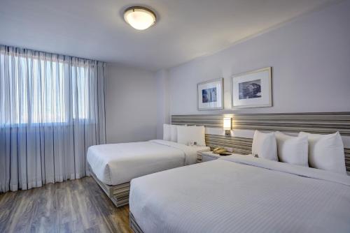 a hotel room with two beds and a window at Town Inn Suites Hotel in Toronto