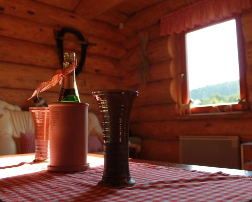 a bottle of champagne and a cup on a table at Srub Losiny in Velké Losiny