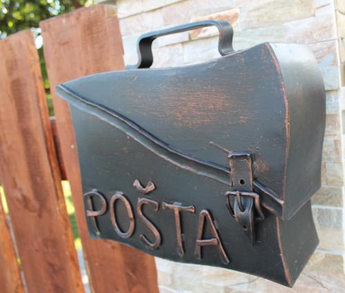 a mailbox with the word postal attached to a wall at Srub Losiny in Velké Losiny