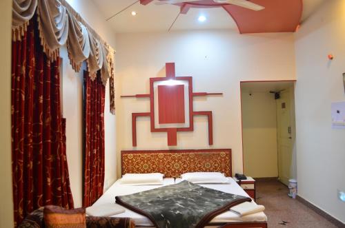 a bedroom with a bed with a red cross on the wall at Hotel Kalyan in Jaipur