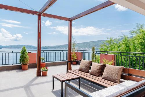 a patio with a couch and a view of the water at Odessa Mama in Bijela