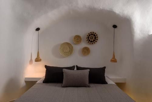 a bedroom with a bed with three hats on the wall at Adele Villa by Senses Collection in Pirgos
