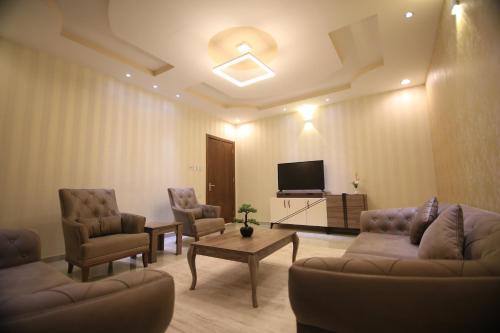 a living room with couches and a flat screen tv at Four Seasons Estate in Taif