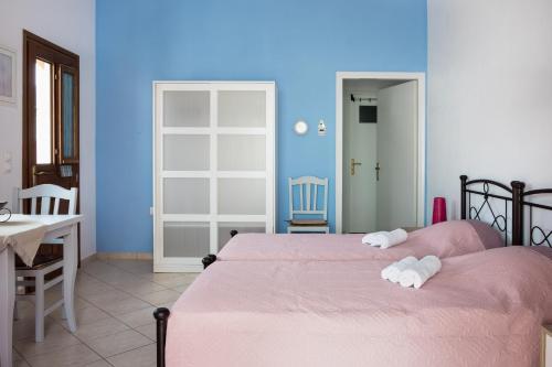 1 dormitorio con 2 camas, mesa y puerta en Cozy & peaceful apartment in Chalki en Khalkíon