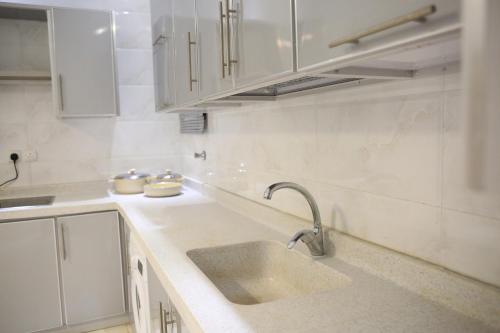 a kitchen with a sink and white cabinets at Four Seasons Estate in Taif