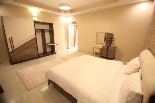 sypialnia z białym łóżkiem i lustrem w obiekcie Four Seasons Estate w mieście Taif