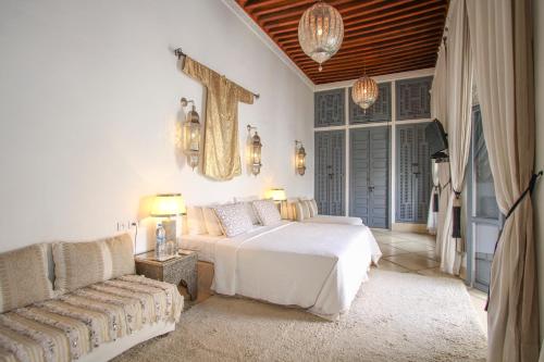 a bedroom with a large bed and a large window at Riad Adore in Marrakesh