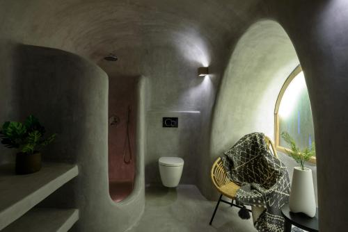 - un salon avec une chaise et un miroir dans l'établissement Adele Villa by Senses Collection, à Pyrgos