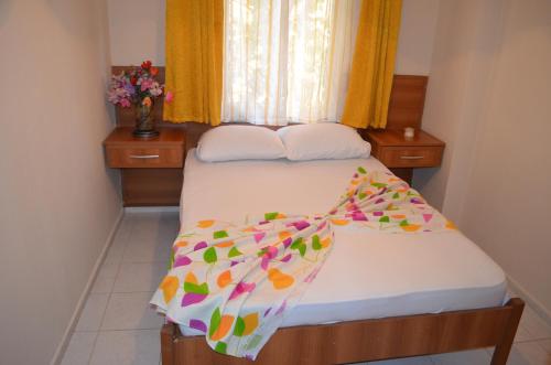 a small bedroom with a bed and a window at Ahmeda Apart Hotel in Ayvalık