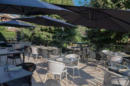 a patio with tables and chairs with umbrellas at Mas du Brulat in Le Castellet