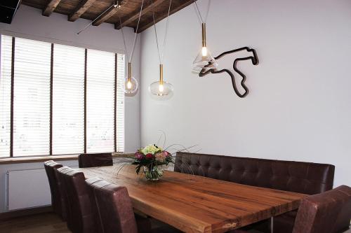 a dining room with a wooden table and leather chairs at Remacle3 in Stavelot