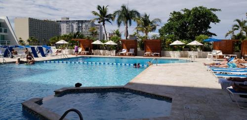 una grande piscina con persone in un hotel di Isla Verde Studio a San Juan