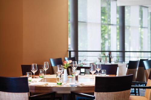 a table with wine glasses on it in a restaurant at Mövenpick Hotel Hamburg City in Hamburg