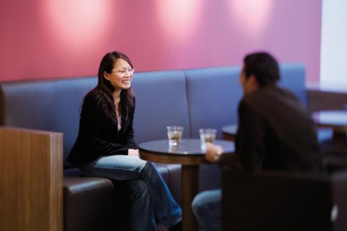 a woman sitting at a table with a man at Mövenpick Hotel Hamburg City in Hamburg
