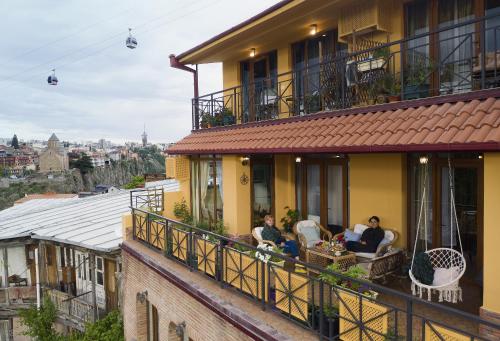 a group of people sitting on the balcony of a building at 160 degrees in Tbilisi City