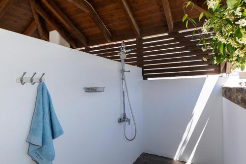 een douche in een witte muur met een blauwe handdoek bij ELENA HOUSE 2 in Gennadi