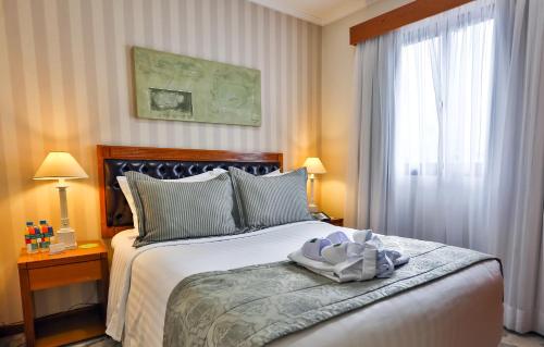 ein Schlafzimmer mit großem Bett und Fenster in der Unterkunft Quality Suites Vila Olimpia in São Paulo