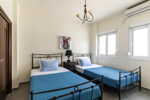 twee bedden in een kamer met twee ramen bij ELENA HOUSE 2 in Gennadi