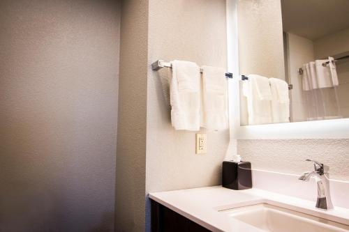 y baño con lavabo, espejo y toallas. en La Quinta by Wyndham Anchorage Airport en Anchorage